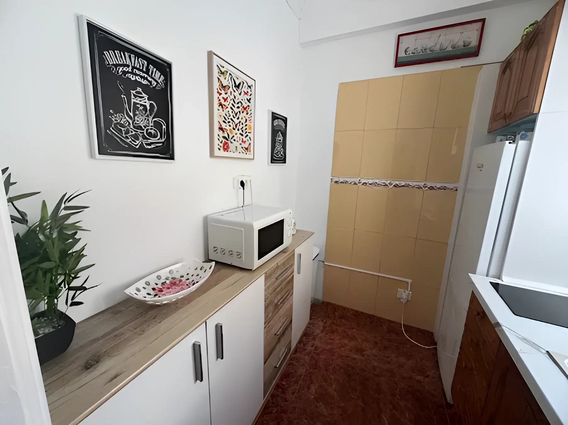 Cocina equipada con microondas, cafetera y menaje