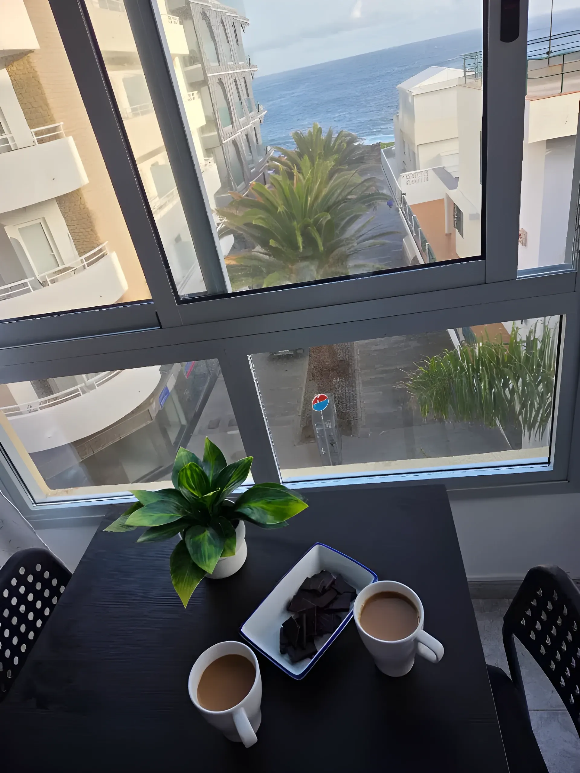 Desayuno en la mesa junto al ventanal con vistas al mar